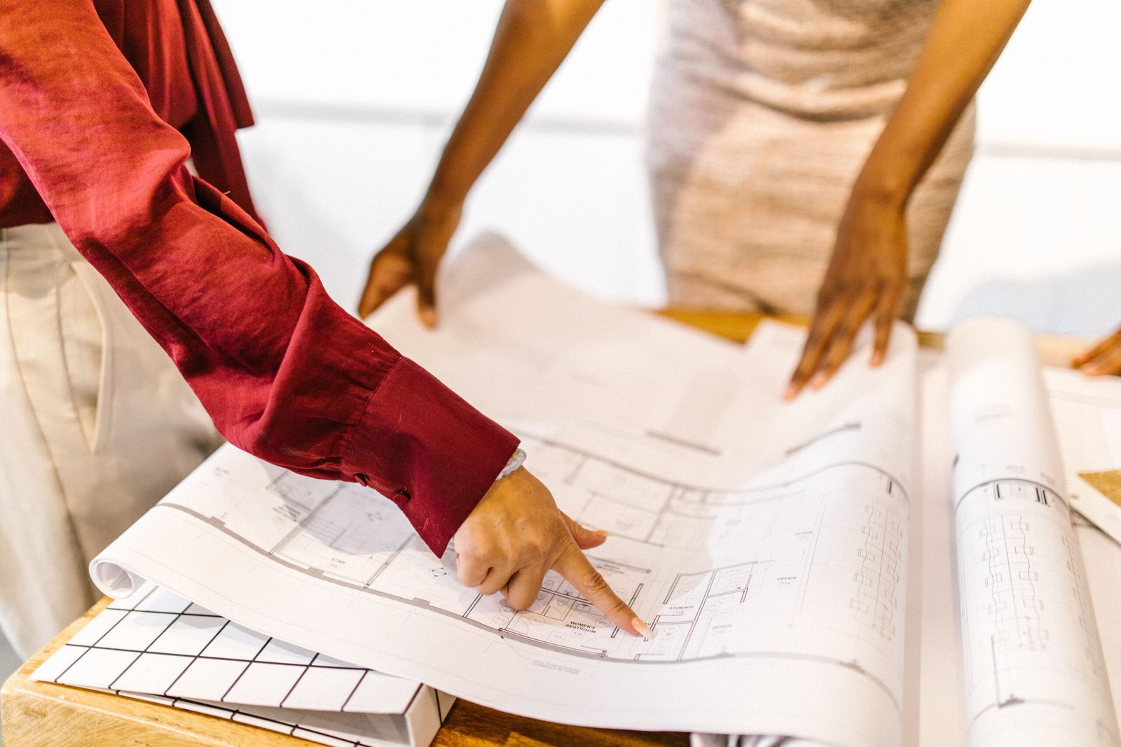 Personas revisando los planos de un proyecto sobre una mesa de trabajo